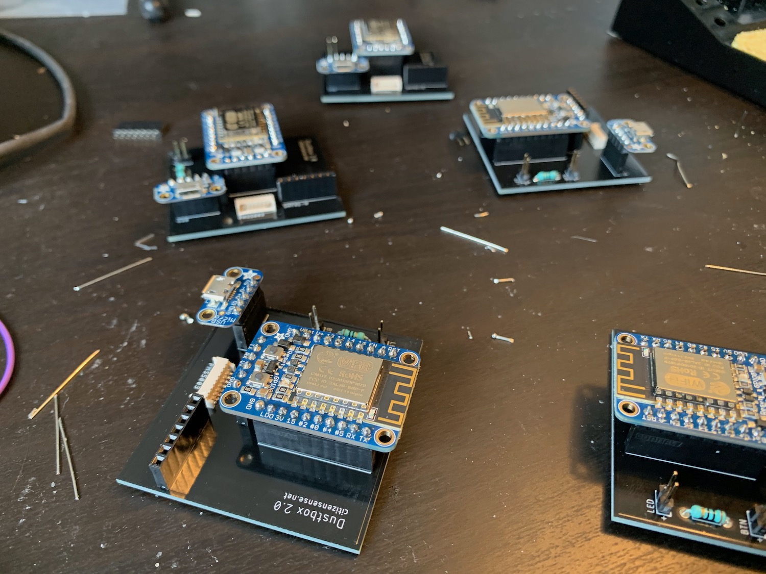 Dustboxes on a desk with breakout boards attached apart from the Sensirion