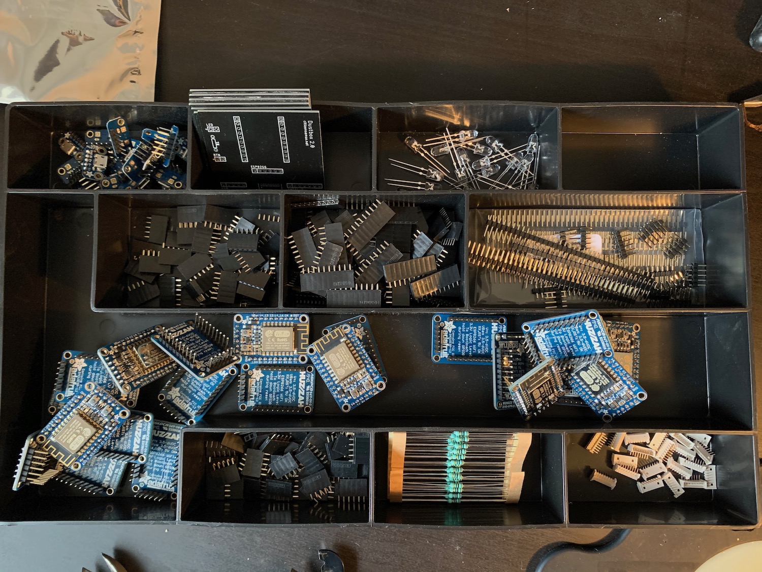 An overhead view of a tray containing sensors, resistors and other electronics parts